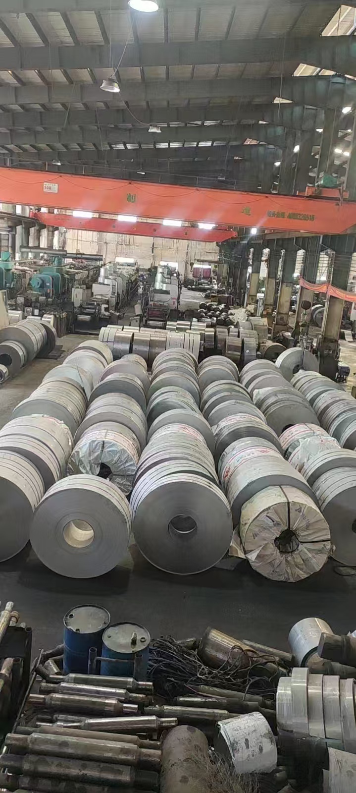 Wide view across stainless steel coil inventory and the factory warehouse